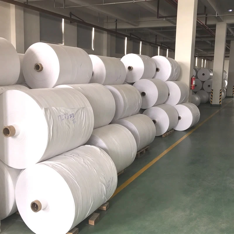 White PP woven fabric rolls stacked three high on pallets in the store